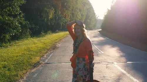 Woman with Guitar Walks Down Country Road