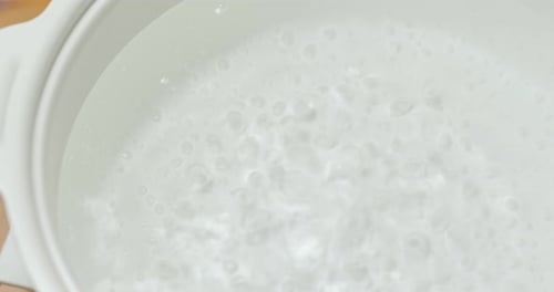 Water Boiling in a White Pot Close Up