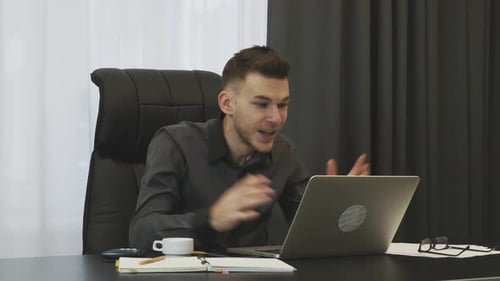 Excited Young Adult Celebrates Success at Workplace