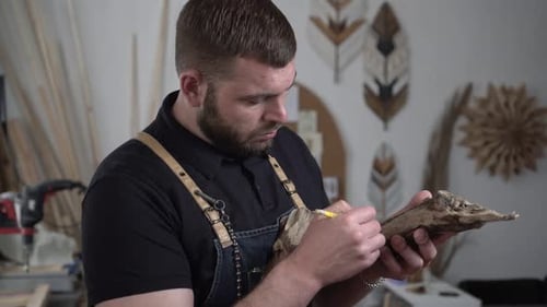 Man Carving Wood Art in Creative Workshop