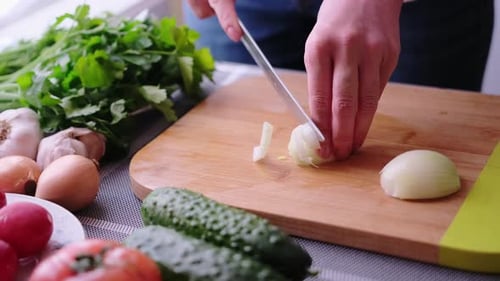 Chopping Fresh Onion on Wood Cutting Board