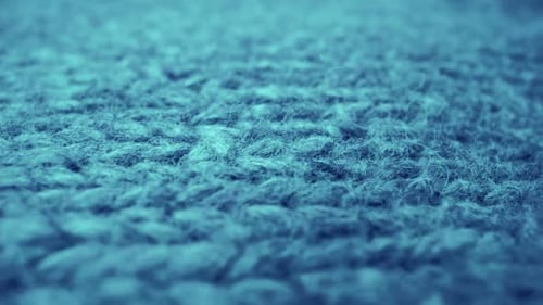 Extreme detail view of sheep wool cloth texture flowing in macro dolly shot.