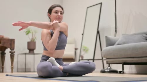 Woman Stretching Arm Sitting on Yoga Mat