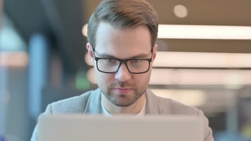Close up of Casual Man Working on Laptop in Office