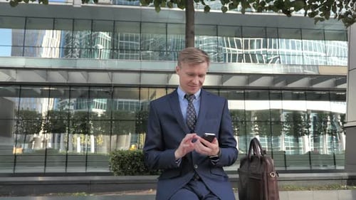 Man in Suit Using Cell Phone Downtown