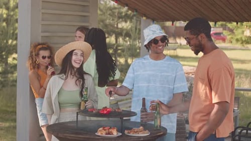 Diverse Company of Friends at Grill Party in Summerhouse