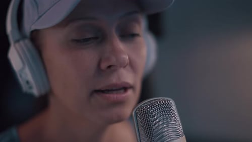 Belle femme avec une casquette et un casque blanc mène une diffusion en direct
