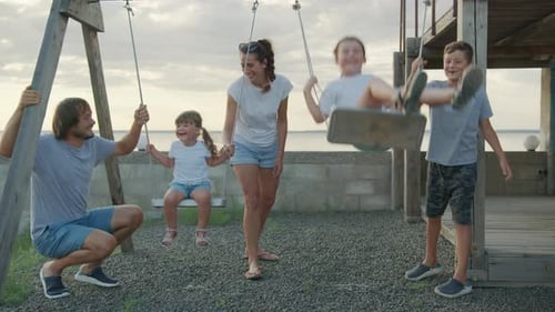 Family Fun on Beach Swings at Sunset