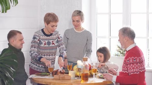 Family Celebrates Christmas Dinner Together at Home