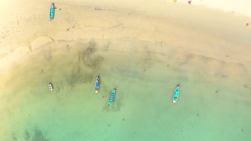 Aerial view or top view of long-tailed boat is floating on the emerald sea. Calm andaman sea at Phuk