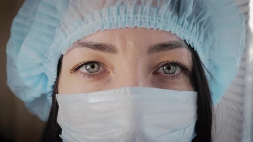 Close-up on Woman's Eyes Wearing Surgical Cap and Mask