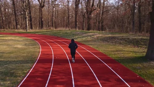 Homem correndo na pista de corrida no estádio
