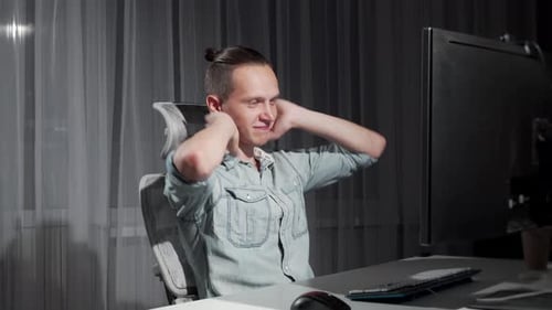 Glücklicher Mann beendet spät in der Nacht die Arbeit an seinem Computer