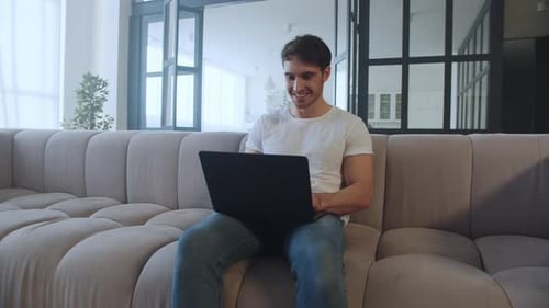 Man Celebrates Good News on Laptop at Home