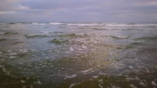 Gliding over waves rolling into beach
