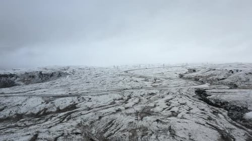 Drone Over Snowy Landscape With Winding Road