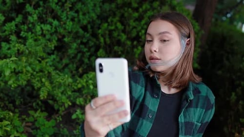 Young Woman Takes Selfie in the Park