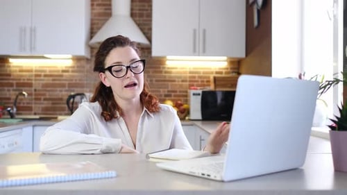 Woman Talking to Laptop in Kitchen Setting
