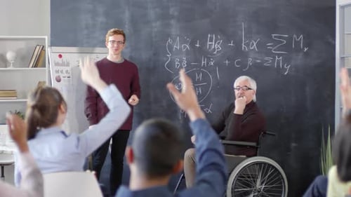Young Teacher Explaining Math to Class with Senior Professor