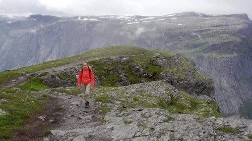 Hiker Walking Over Rocky Mountain Peak