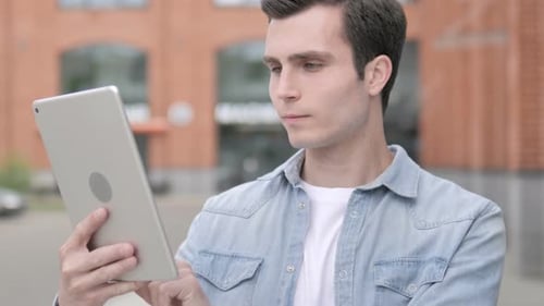 Young Man Using Tablet Computer Outdoors