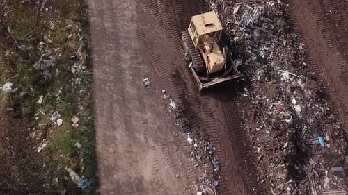 Bulldozer Pushing Garbage in a Rural Landfill