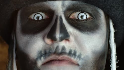 Close-up of Scary Man Face in Skull Halloween Makeup of Skeleton Showing Dirty Teeth and Tongue