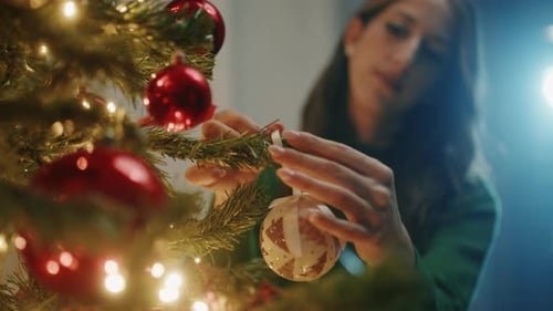 Woman Decorating Christmas Tree with Ornaments