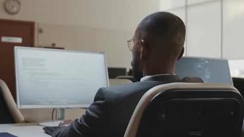 Man Working on Computer Code in Modern Office