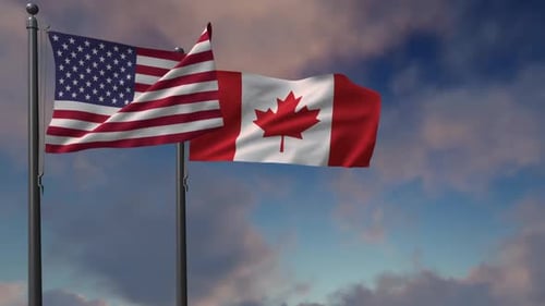 USA and Canada Flags Waving on Flagpoles Against Sky