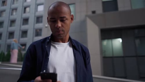 Ethnic Man Using Smartphone on Street