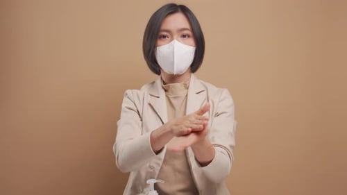 Woman Applies Hand Sanitizer Wearing Face Mask
