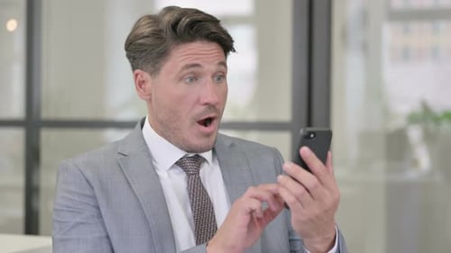 Man in Suit Reacts Positively to Phone