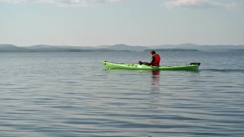 Person Kayaking on Lake in Wilderness Setting