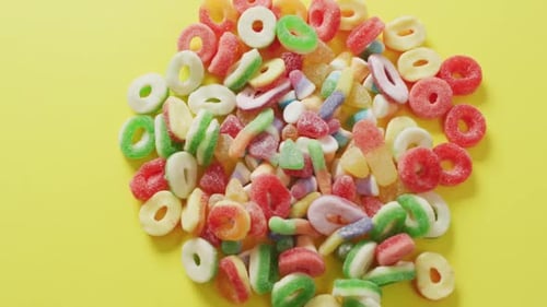 Video of colourful jelly candy on yellow background