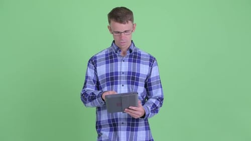 Young Adult Man Using Tablet, Standing, Thinking