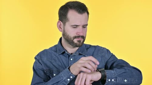 Professioneller Bart Junger Mann mit Smartwatch, gelber Hintergrund