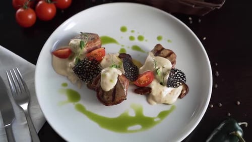 Plated Beef Meal with Sauce and Tomatoes