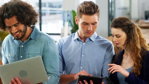 Business executives using laptop, mobile phone and digital tablet