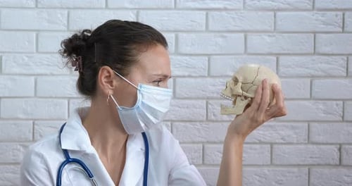Doctor look at skull view. A view of a doctor in mask with a human skull.