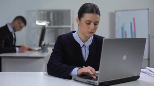 Woman Typing on a Laptop in an Office