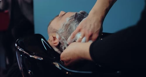 Barber Washing Customer's Hair and Beard