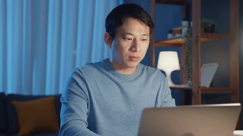 Young Adult Working Late at Home on Laptop