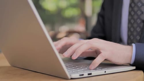 Hands of Businessman Typing on Laptop
