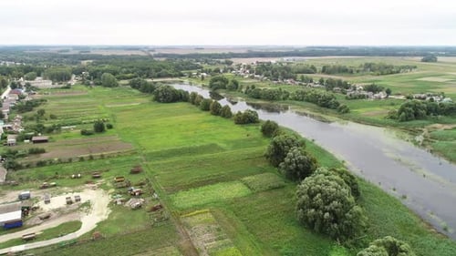 Großes Dorf geteilt durch einen großen See. Ein flacher See, dessen Ufer mit dichten Sträuchern bedeckt sind
