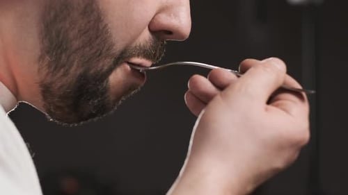 Close Up View of Bearded Person Eating Food From Fork