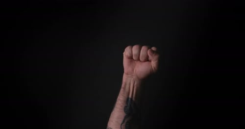 Raised Fist Against Black Background