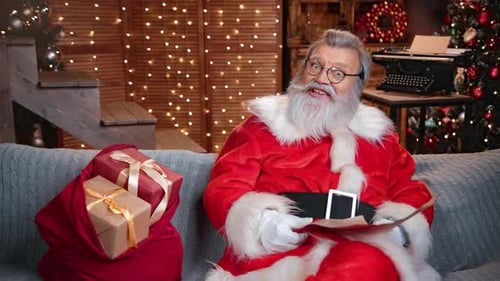 Santa Claus Reading List by Fireplace at Christmas