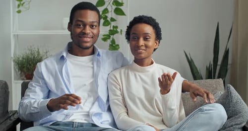 Webcam View of Young Ethnic Mixed Race Couple Man and Woman Sitting at Home on Couch Talking To