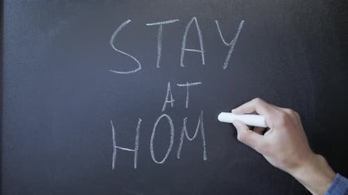 Hand Writing 'Stay Home' on Chalkboard